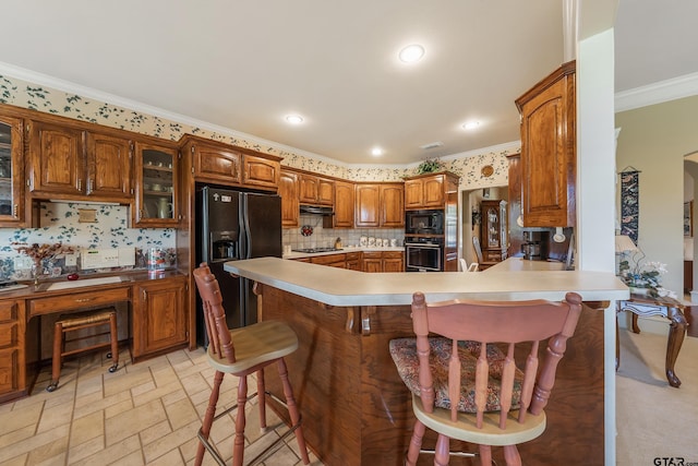 kitchen featuring black appliances, kitchen peninsula, tasteful backsplash, a kitchen breakfast bar, and ornamental molding