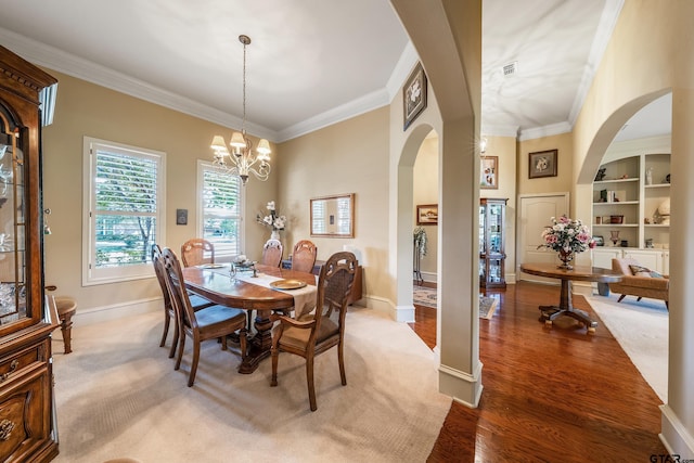 dining area featuring an inviting chandelier, wood-type flooring, and crown molding