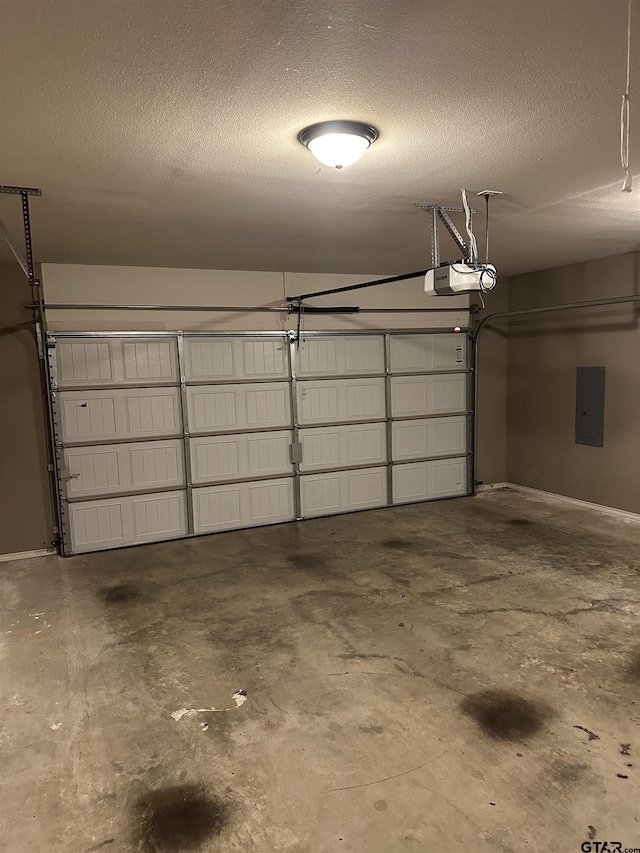 garage with baseboards, a garage door opener, and electric panel