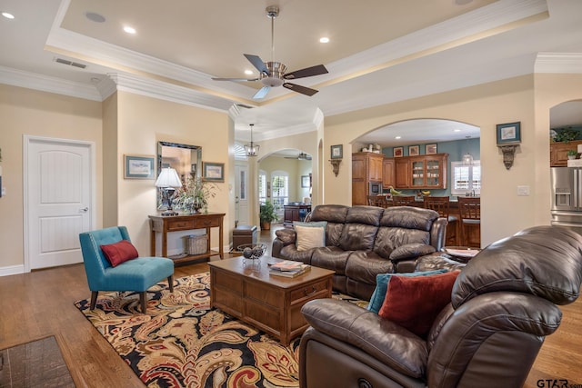 265 Bunker Dr, Tyler, TX 75703 - living room featuring arched walkways, a tray ceiling, a ceiling fan, ornamental molding, and recessed lighting