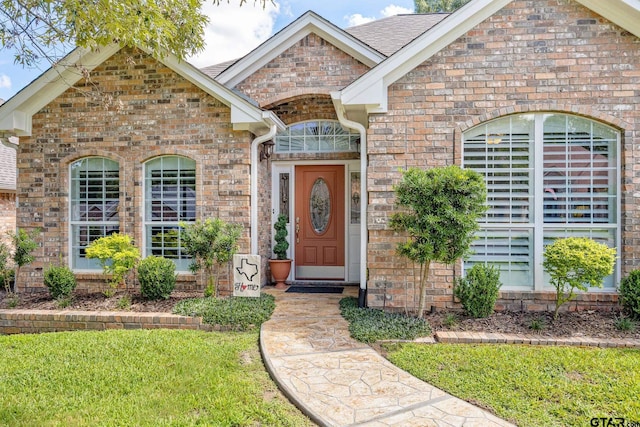 265 Bunker Dr, Tyler, TX 75703 - view of front of home featuring brick siding, a front lawn, and roof with shingles
