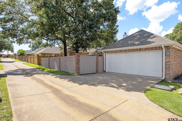 265 Bunker Dr, Tyler, TX 75703 - view of side of home featuring driveway, brick siding, roof with shingles, a garage, and a chimney
