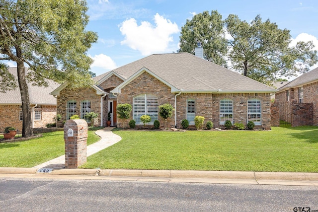 265 Bunker Dr, Tyler, TX 75703 - view of front of home with a front yard, roof with shingles, brick siding, and a chimney