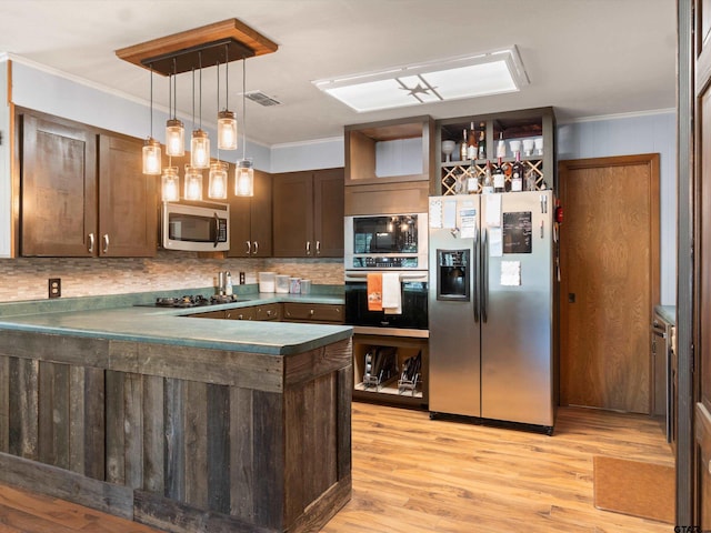 kitchen featuring crown molding, kitchen peninsula, dark brown cabinetry, and black appliances