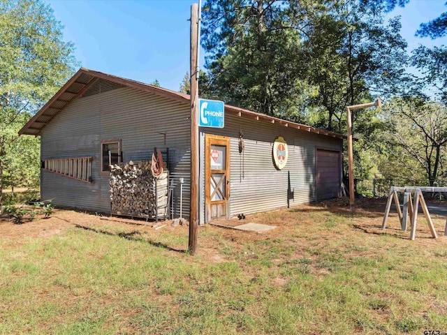 view of side of property featuring a lawn and an outdoor structure