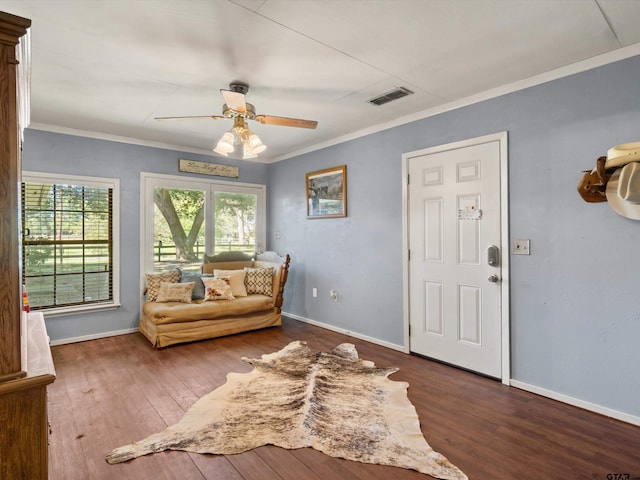 interior space with dark wood-type flooring, ceiling fan, and ornamental molding