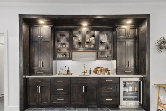 bar featuring dark brown cabinets, sink, and wine cooler