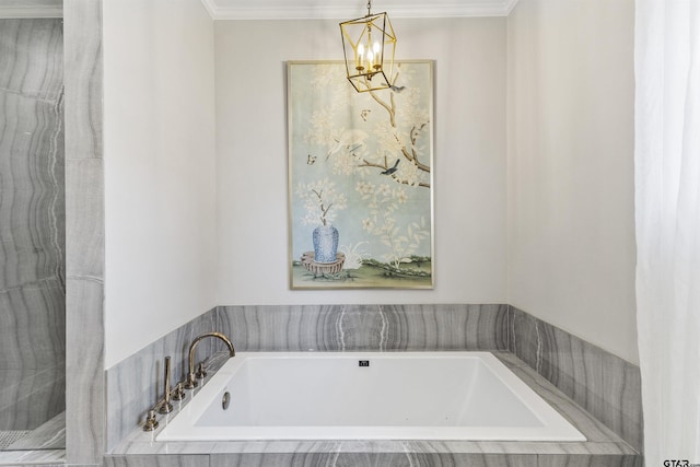 bathroom with tiled tub, crown molding, and a notable chandelier