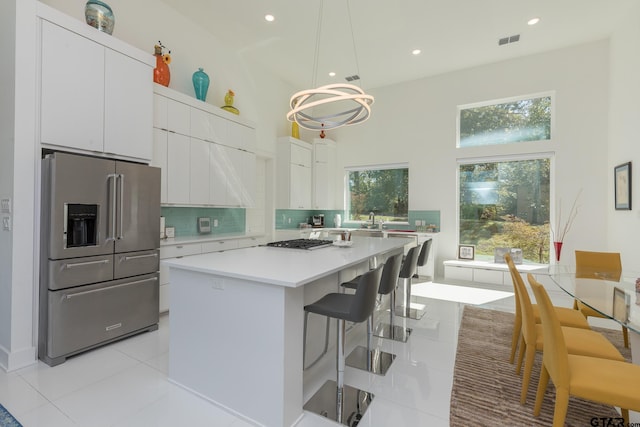 kitchen with hanging light fixtures, appliances with stainless steel finishes, a center island, and white cabinets