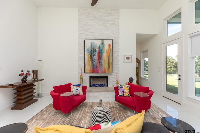 living room with tile patterned floors, a fireplace, and a high ceiling