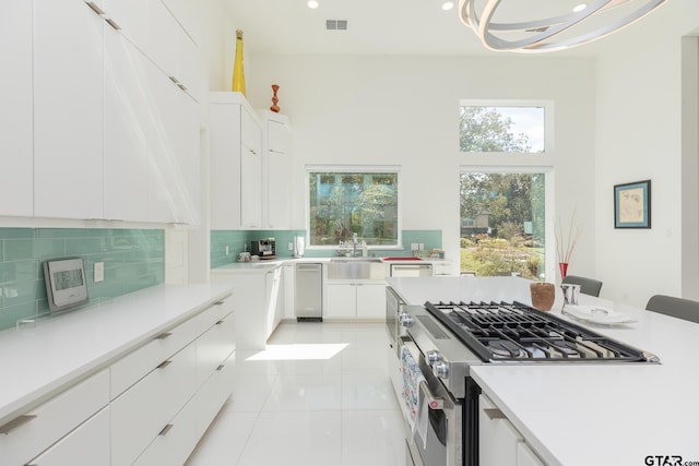 kitchen featuring stainless steel appliances, white cabinetry, and light tile patterned flooring