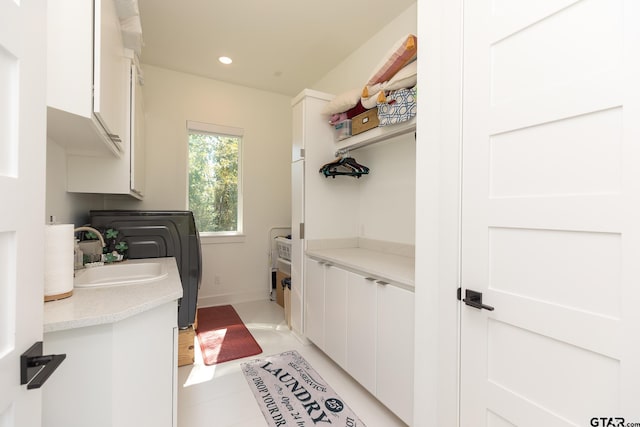 laundry room featuring cabinets, washer / dryer, and sink