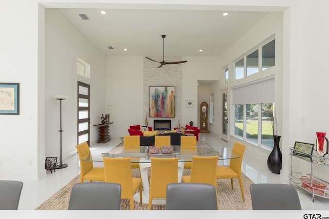 dining room featuring a towering ceiling and a fireplace