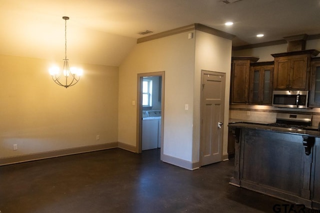 kitchen featuring decorative light fixtures, washer / dryer, vaulted ceiling, appliances with stainless steel finishes, and ornamental molding