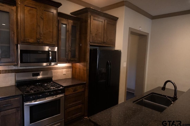 kitchen with sink, crown molding, decorative backsplash, dark brown cabinets, and appliances with stainless steel finishes