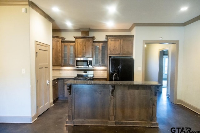 kitchen with a center island with sink, a kitchen breakfast bar, ornamental molding, and appliances with stainless steel finishes