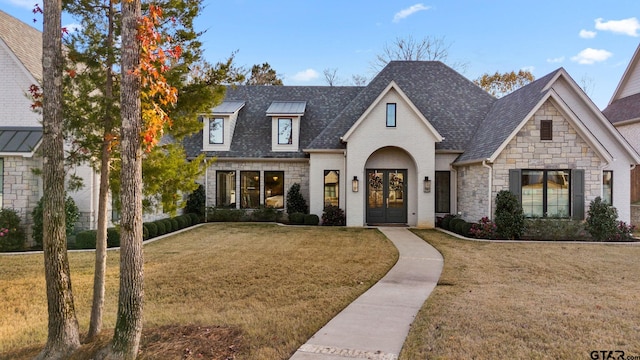 french country style house with a front yard and french doors