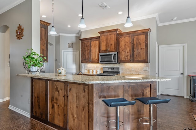 kitchen featuring black range, crown molding, light stone countertops, decorative light fixtures, and kitchen peninsula