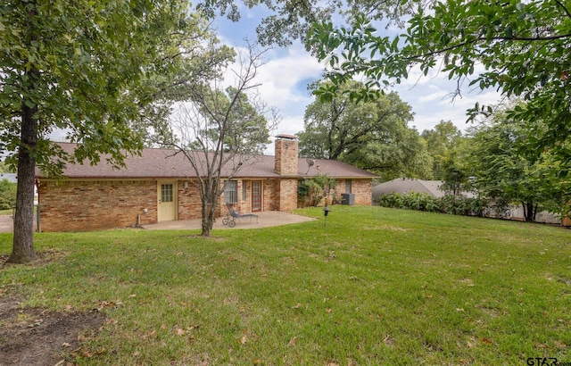 back of property with a yard and a patio area