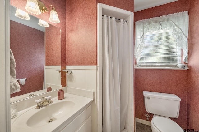 bathroom with walk in shower, vanity, and toilet