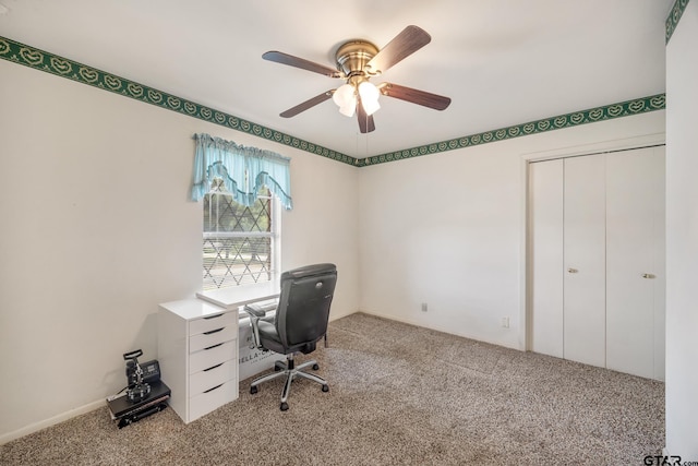 unfurnished office featuring ceiling fan and carpet