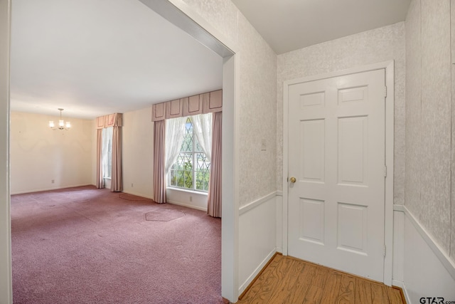 entrance foyer featuring light colored carpet and a notable chandelier