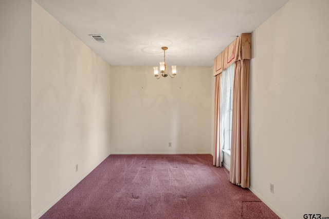 spare room with a chandelier and carpet