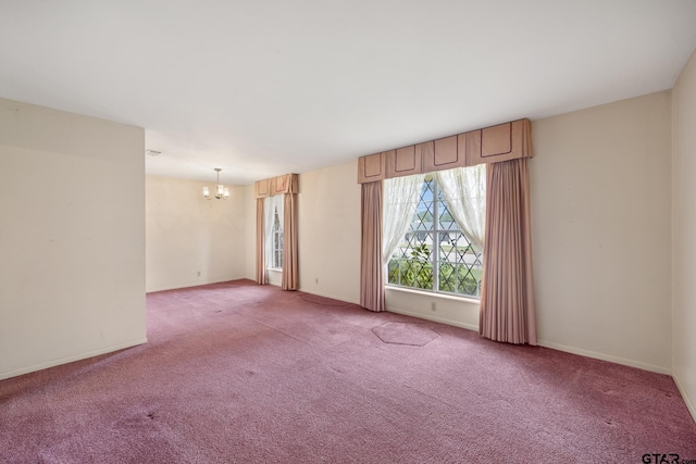 carpeted spare room with a notable chandelier