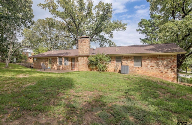 rear view of house featuring a patio, central AC, and a yard