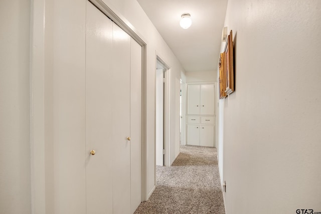 hallway featuring light colored carpet