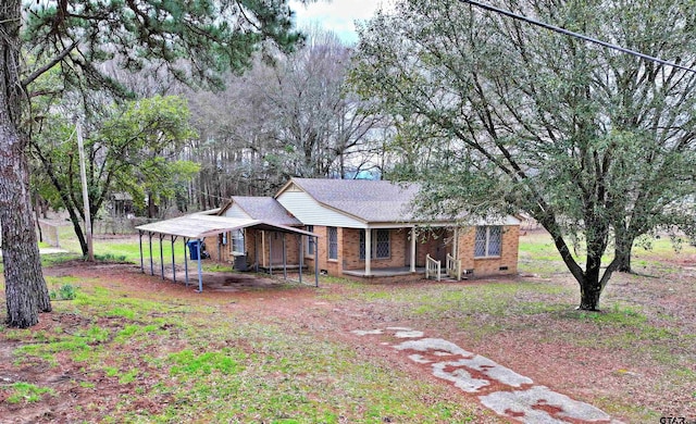 view of front of home with a detached carport, covered porch, brick siding, and crawl space