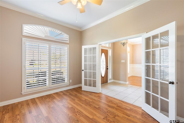 interior space featuring a wealth of natural light, ornamental molding, and french doors