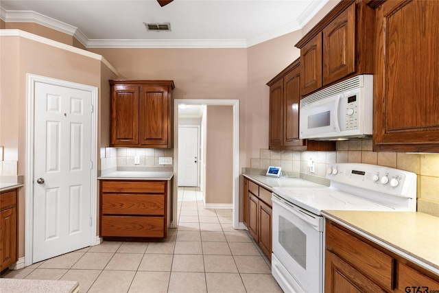 kitchen featuring decorative backsplash, light tile patterned flooring, and white appliances