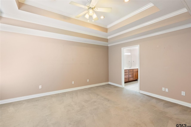 carpeted empty room with a raised ceiling, ceiling fan, and crown molding