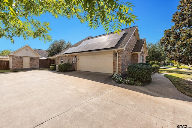 view of side of home with a garage and solar panels