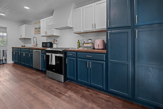 9331 Londonderry Dr, Tyler, TX 75703 - kitchen featuring blue cabinets, stainless steel appliances, butcher block counters, premium range hood, and dark wood-style flooring