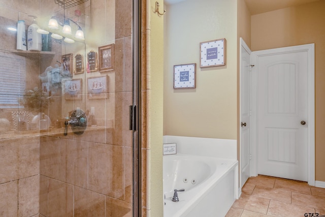 bathroom featuring a stall shower, tile patterned flooring, and a jetted tub