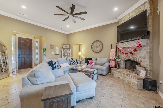 living room featuring light tile patterned floors, baseboards, visible vents, ornamental molding, and a fireplace