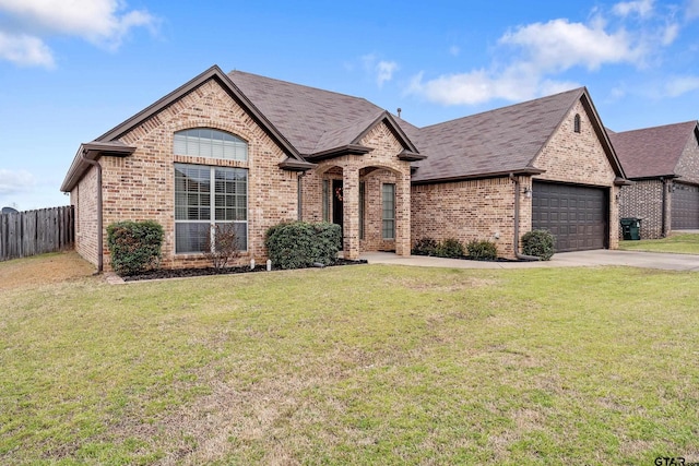 french country home featuring an attached garage, brick siding, fence, and a front lawn