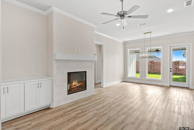 unfurnished living room with light hardwood / wood-style flooring, ceiling fan with notable chandelier, ornamental molding, and a fireplace