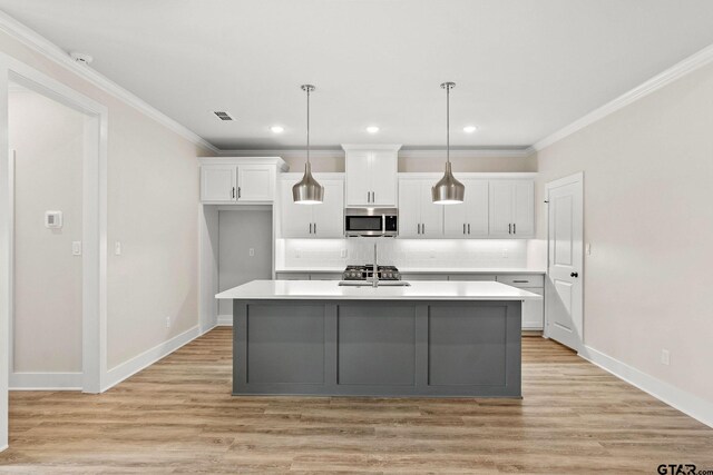 kitchen with light wood-type flooring, white cabinetry, a kitchen island with sink, and stainless steel appliances