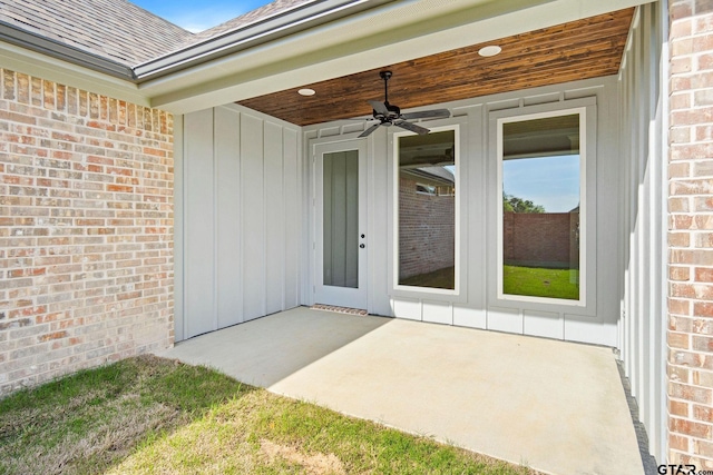 view of exterior entry with ceiling fan and a patio area