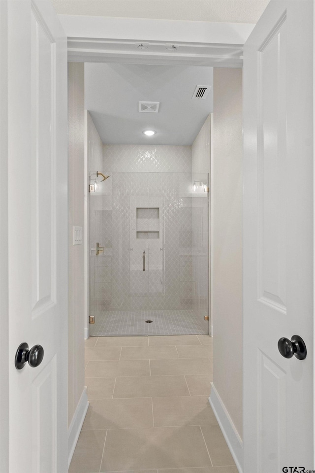 bathroom featuring tile patterned flooring and a shower with door