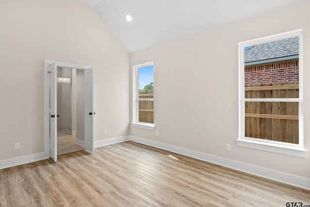 unfurnished bedroom featuring light hardwood / wood-style floors and lofted ceiling