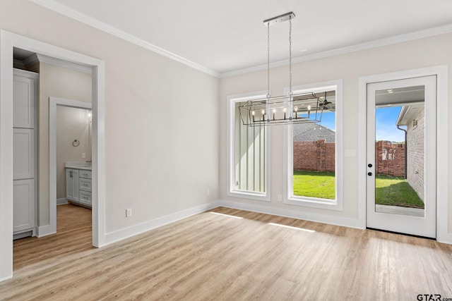 unfurnished dining area featuring light wood-type flooring, a notable chandelier, and ornamental molding