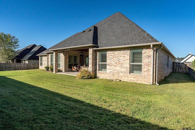 back of house featuring a yard and a patio area