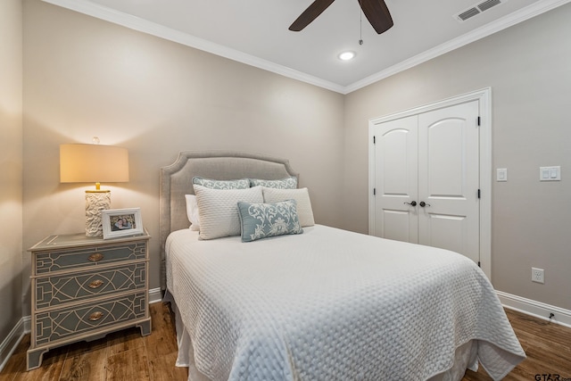 bedroom with dark wood-type flooring, ceiling fan, a closet, and ornamental molding