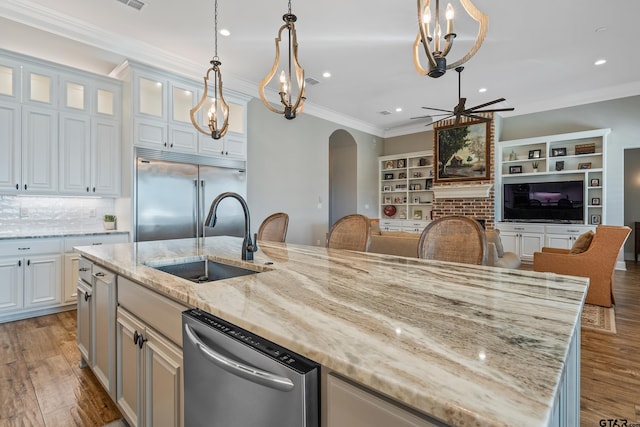 kitchen featuring stainless steel appliances, white cabinets, sink, a kitchen island with sink, and light hardwood / wood-style flooring