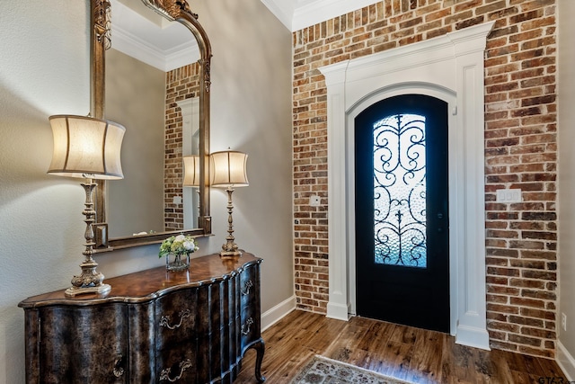 foyer entrance with dark wood-type flooring and ornamental molding