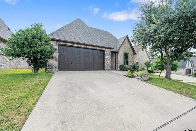 7216 Princedale, Tyler, TX 75703 - french country style house featuring a front yard, an attached garage, brick siding, a shingled roof, and driveway